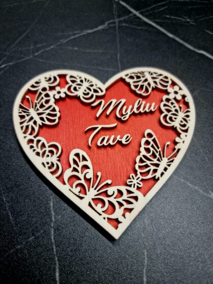 Medinė dviejų sluoknsių širdelė (raudonos ir natūralios medžio spalvos) juodame fone valentino dienai